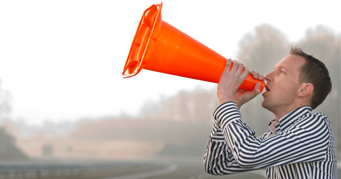 Man yelling into a traffic cone.